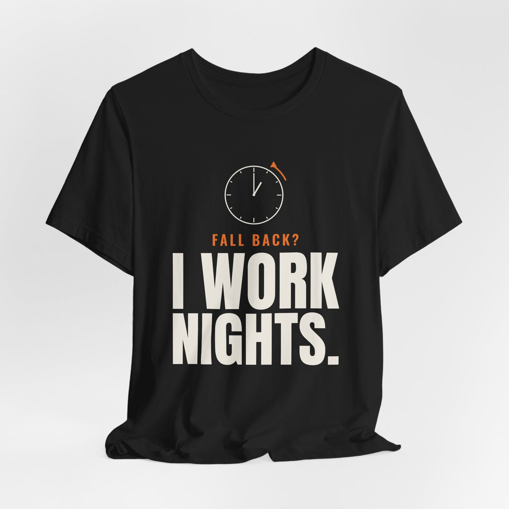Black night shift tee with a clock turning back and "FALL BACK? I WORK NIGHTS." in orange and bold type, on a soft gray backdrop