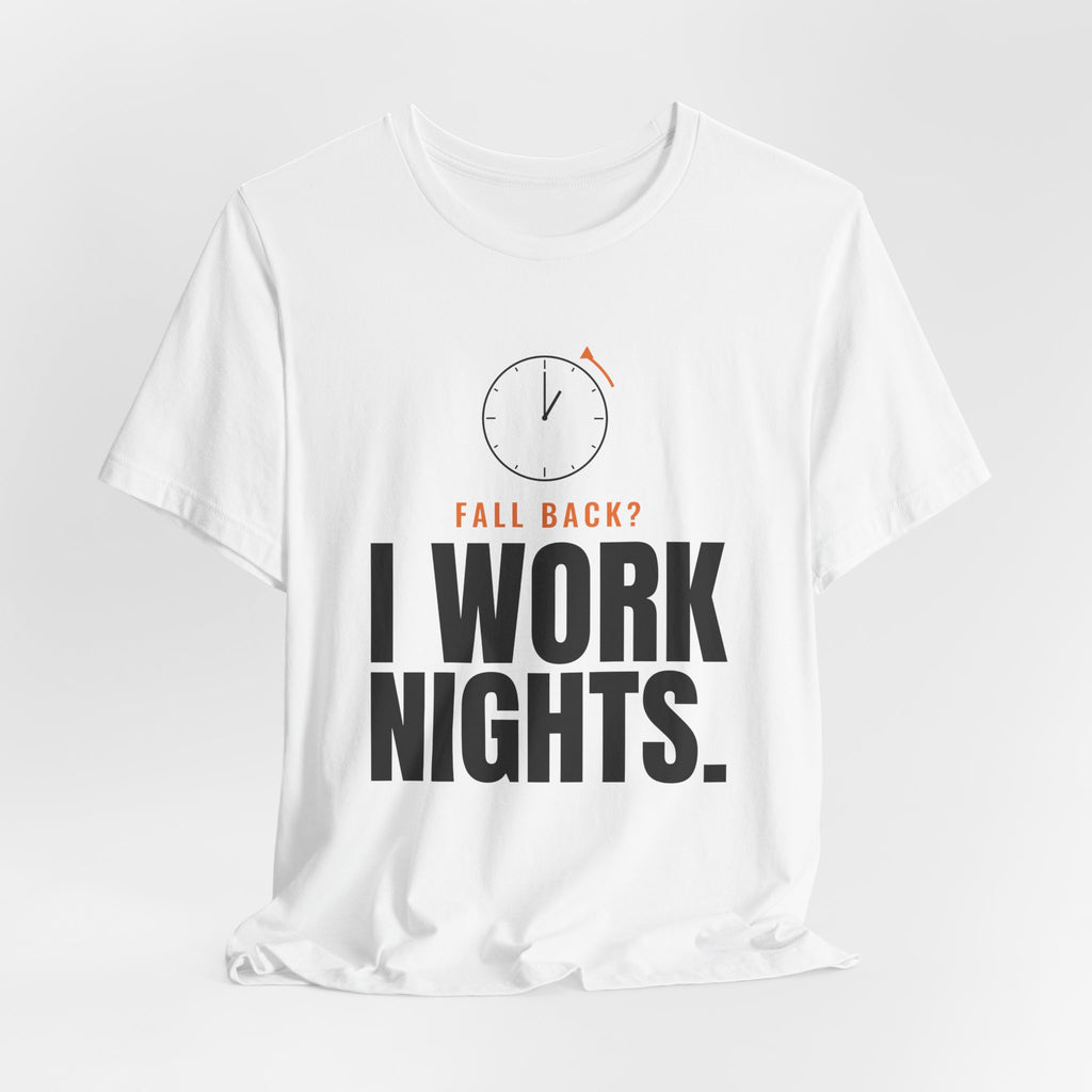 White night shift tee with a clock turning back and "FALL BACK? I WORK NIGHTS." in orange and bold type, on a soft gray backdrop