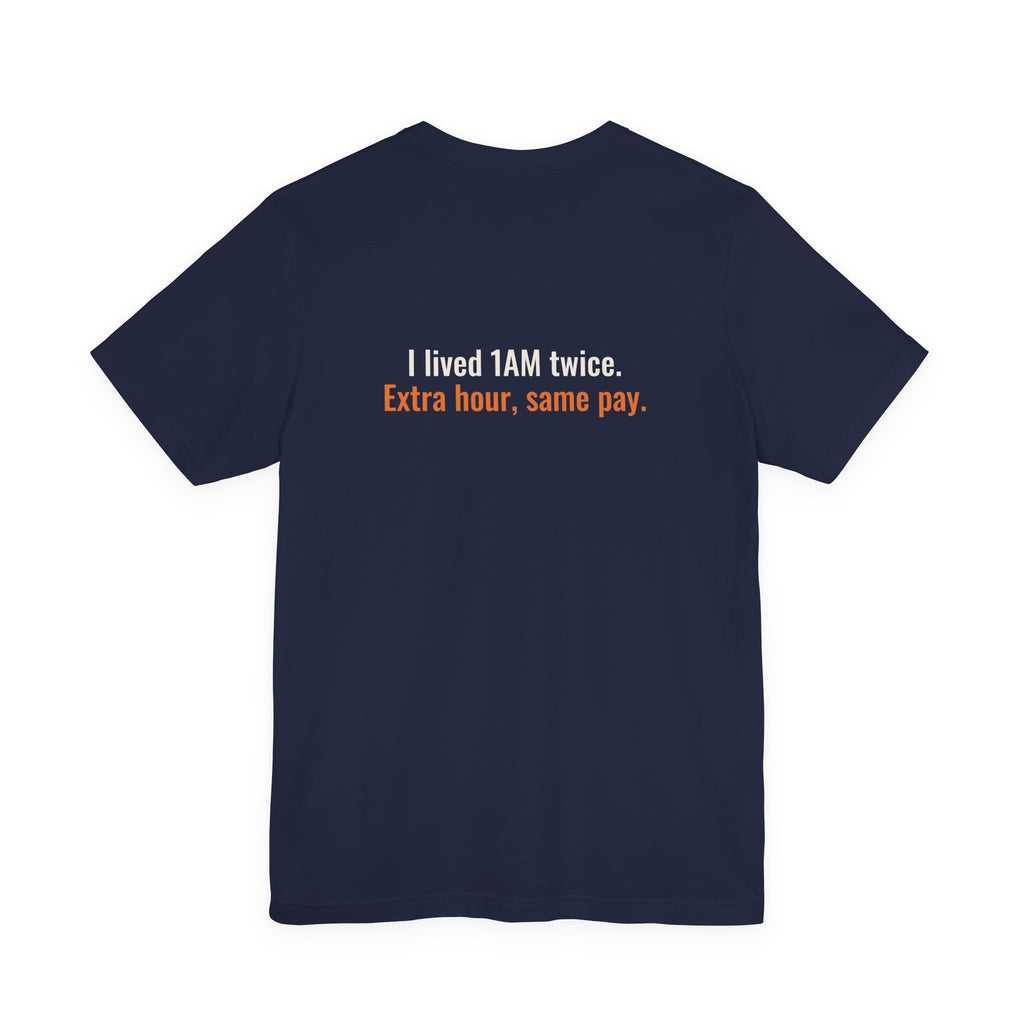 Back of the navy tee printed with the small slogan "I lived 1AM twice. Extra hour, same pay."