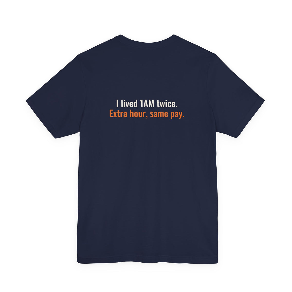 Back of the navy tee printed with the small slogan "I lived 1AM twice. Extra hour, same pay."